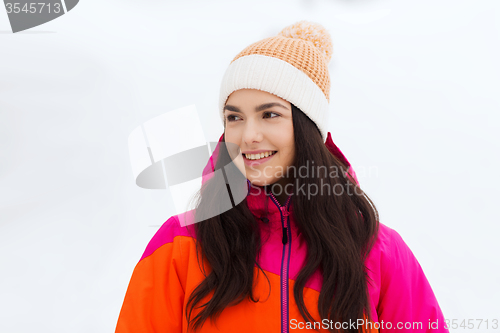 Image of happy young woman in winter clothes outdoors