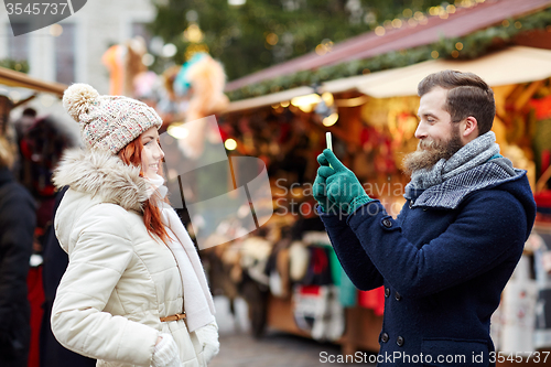 Image of couple taking selfie with smartphone in old town