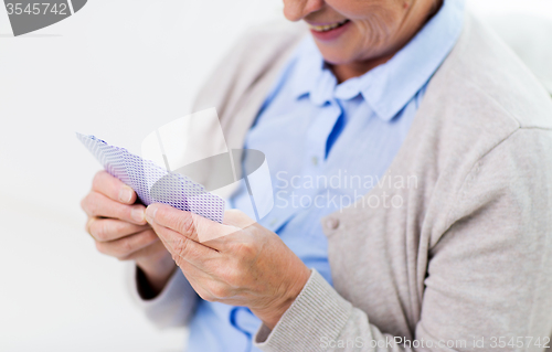 Image of close up of happy senior woman playing cards