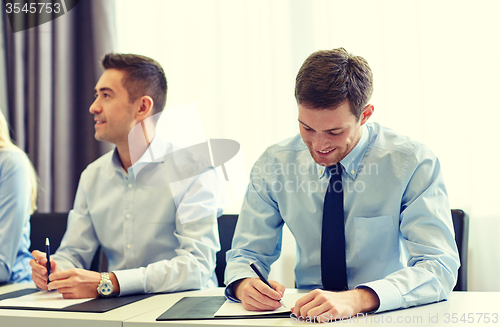 Image of group of smiling businesspeople meeting in office