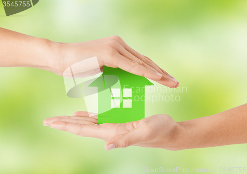 Image of close up of woman hands holding green house