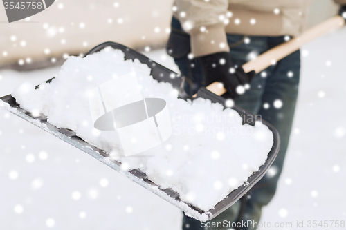 Image of closeup of man digging snow with shovel