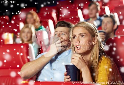 Image of friends or couple watching horror movie in theater