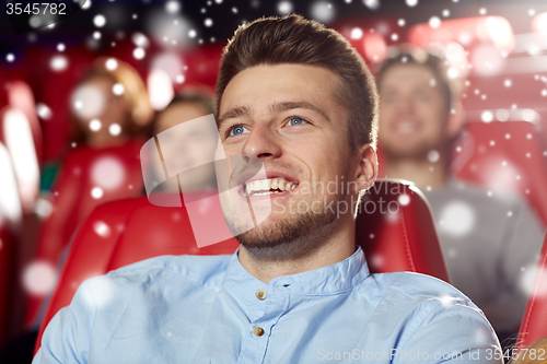 Image of happy young man watching movie in theater