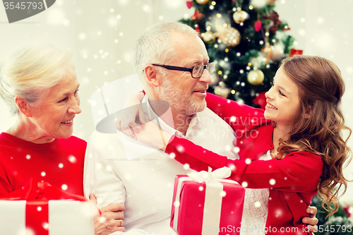 Image of smiling family with gifts at home