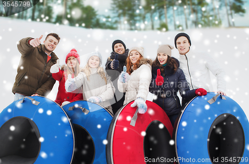 Image of group of smiling friends with snow tubes