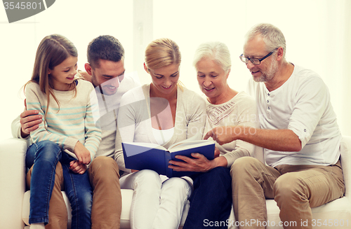 Image of happy family with book or photo album at home