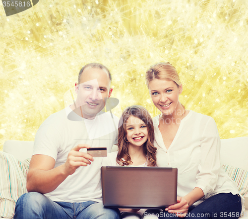 Image of happy family with laptop computer and credit card