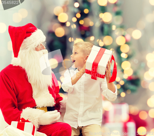 Image of smiling little boy with santa claus and gifts