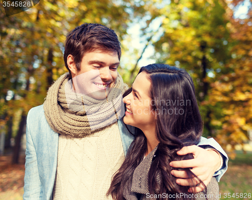 Image of smiling couple hugging in autumn park