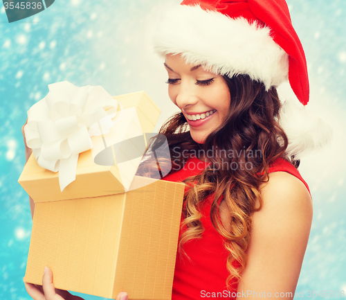 Image of smiling woman in santa helper hat with gift box