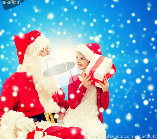 Image of smiling little girl with santa claus and gifts