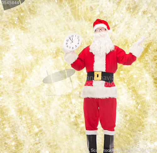 Image of man in costume of santa claus with clock