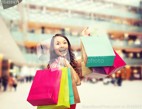 Image of smiling woman with colorful shopping bags