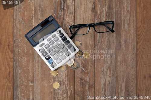 Image of calculator, eyeglasses and euro coins on table