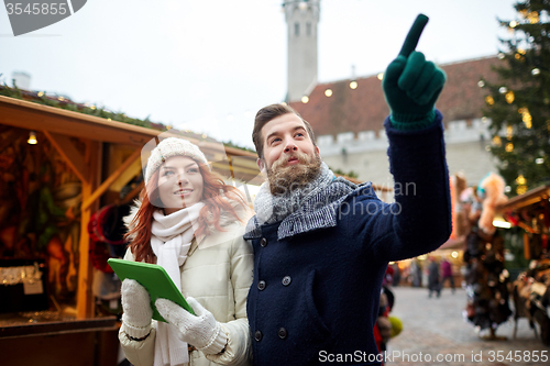 Image of happy couple walking with tablet pc in old town