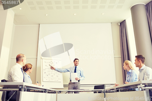 Image of group of smiling businesspeople meeting in office