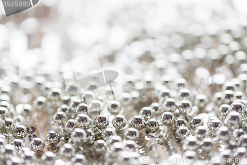 Image of close up of silver beads on shiny sequined texture