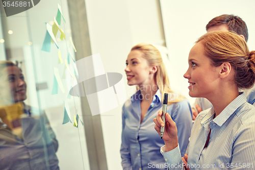 Image of smiling business people with marker and stickers