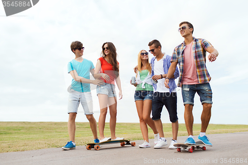 Image of happy teenage friends with longboards outdoors