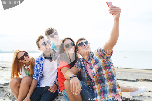 Image of happy friends with smartphone taking selfie