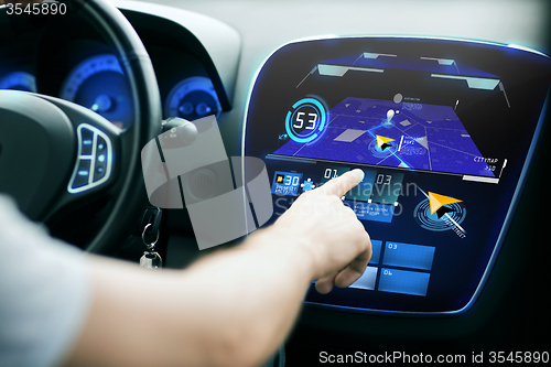 Image of male hand using navigation system on car dashboard