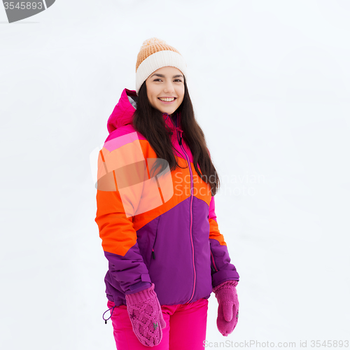 Image of happy young woman in winter clothes outdoors