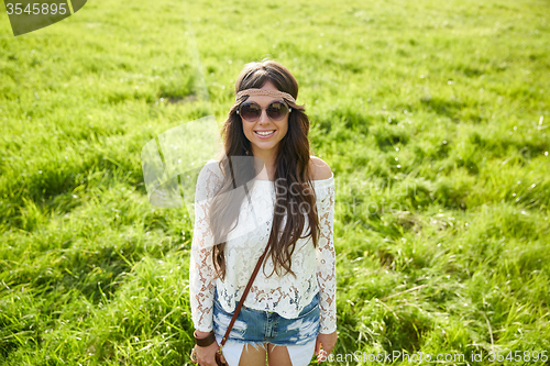 Image of smiling young hippie woman on green field