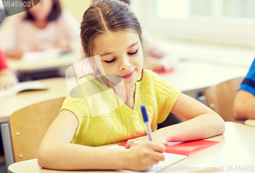 Image of group of school kids writing test in classroom