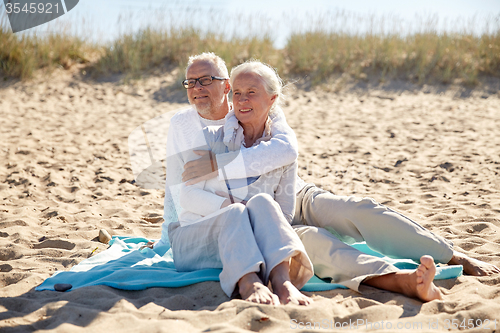 Image of happy senior couple hugging on summer beach