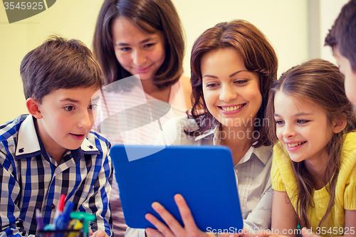 Image of group of kids with teacher and tablet pc at school