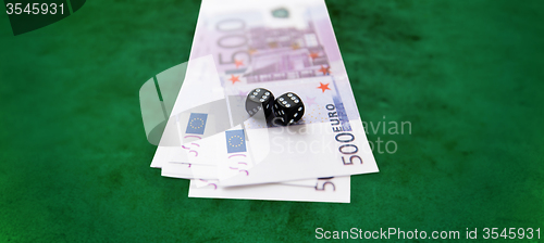 Image of close up of black dice and euro cash money