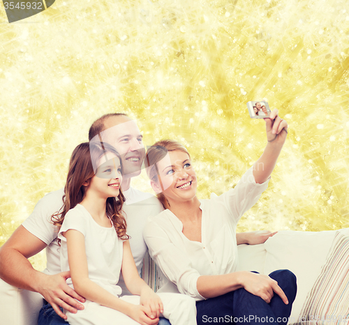 Image of happy family with camera at home