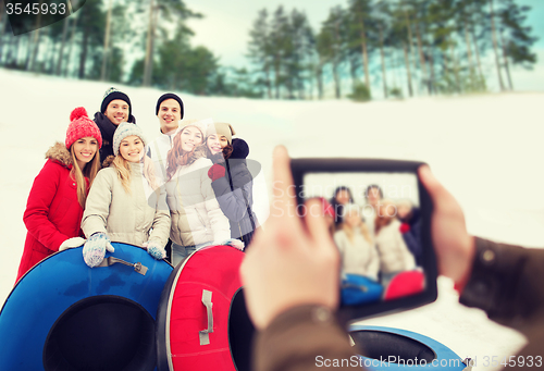 Image of group of smiling friends with snow tubes