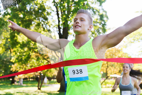 Image of happy young male runner winning on race finish