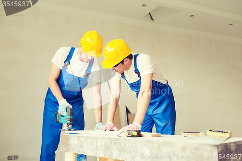 Image of group of builders with tools indoors