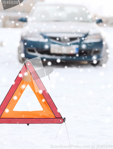 Image of closeup of warning triangle and car