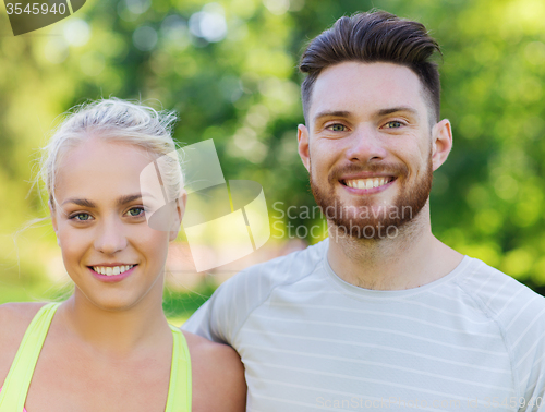 Image of happy friends or sportsmen couple hugging outdoors