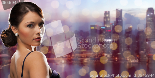 Image of woman with diamond earring over night city