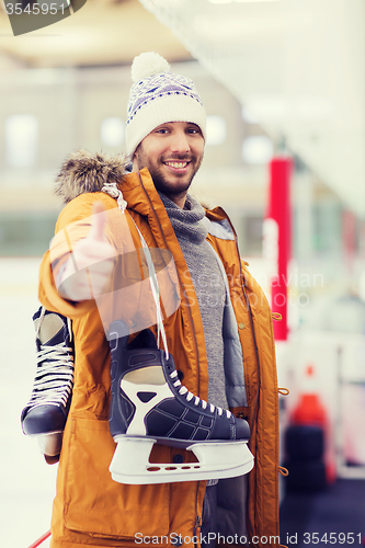 Image of happy young man showing thumbs up on skating rink