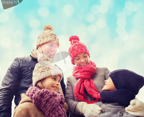 Image of happy family in winter clothes outdoors