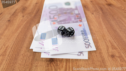 Image of close up of black dice and euro cash money