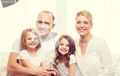 Image of smiling parents and two little girls at home