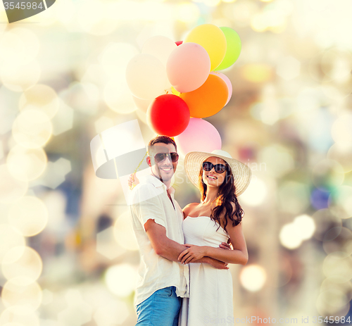 Image of smiling couple with air balloons outdoors