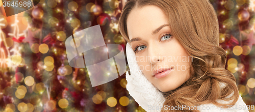 Image of woman in gloves over christmas lights background