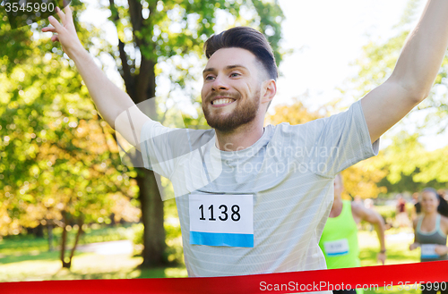 Image of happy young male runner winning on race finish