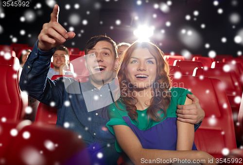 Image of happy couple watching movie in theater