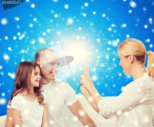 Image of happy family with camera at home