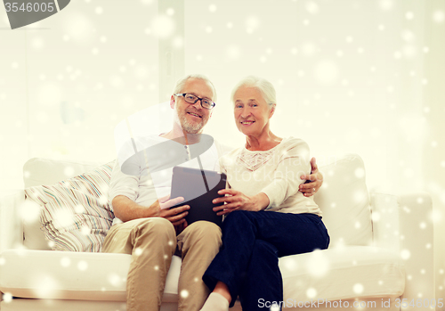Image of happy senior couple with tablet pc at home