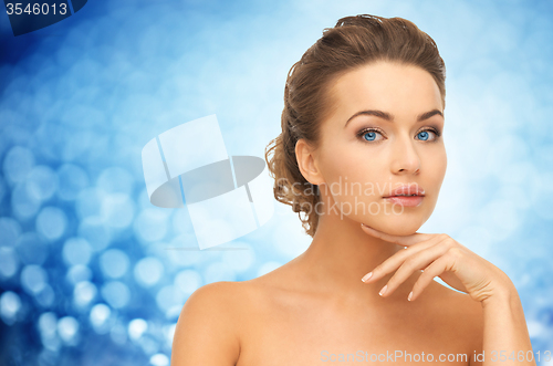 Image of beautiful young woman touching her face and neck